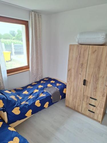 a bedroom with a bed and a wooden cabinet at Veszei Apartman in Békéscsaba