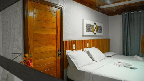a bedroom with a bed and a wooden door at Casa das Seringueiras in Alter do Chao