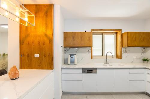 a kitchen with white counters and wooden cabinets at אחוזת שרון in Elifelet