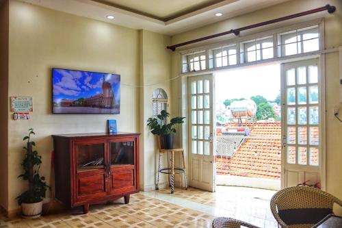 a living room with a tv on the wall at TeeDalat House in Khu Chi Lăng