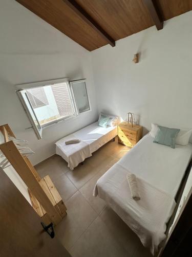 a room with two beds and a window at Casa El Palmar - Playa y Jardín in El Palmar