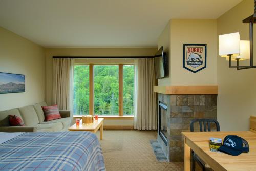 a hotel room with a bed and a fireplace at Burke Mountain Hotel in East Burke