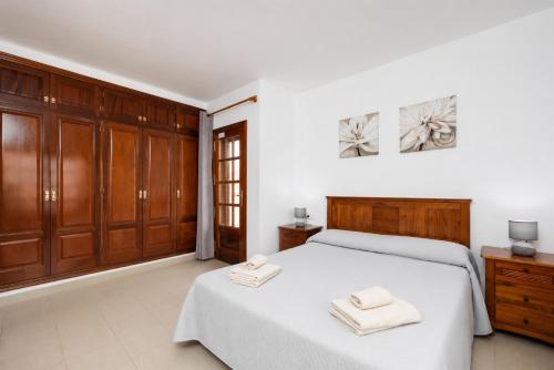 a bedroom with a bed and wooden cabinets at Villa Alexsandra in Playa Blanca