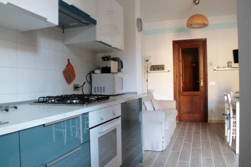 ヴィアレッジョにあるLa Casa in Passeggiata - Seancityのキッチン(青いキャビネット、コンロ付)