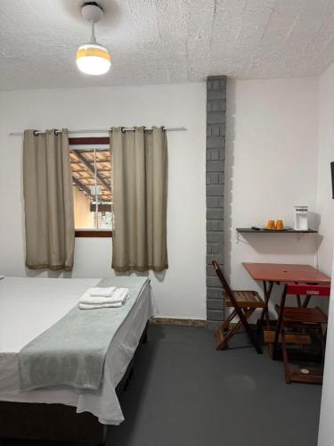 a room with a bed and a table and a window at Suites Prime in Marataizes