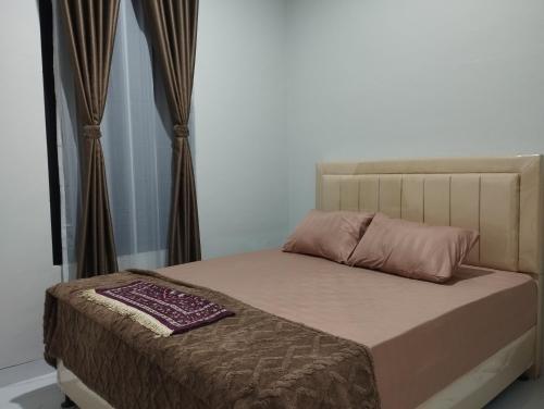 a bed in a bedroom with at Hasbi Homestay Syariah in Bukittinggi