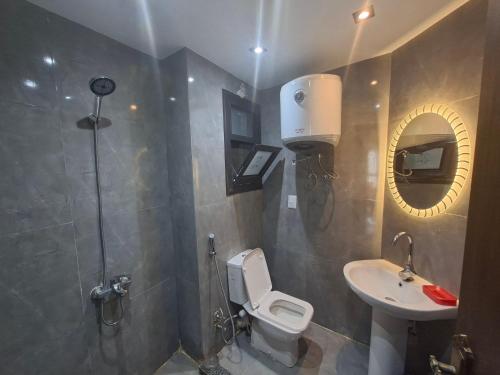 a bathroom with a toilet and a sink and a mirror at شاليه غرفتين ببورتوسعيد للعائلات فقط in Port Said