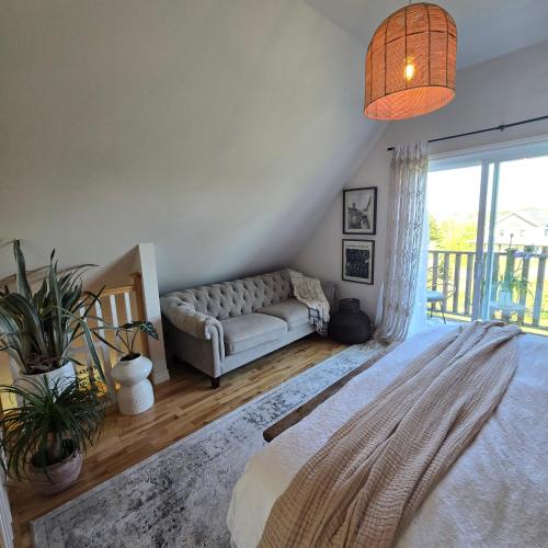 a living room with a couch and a large window at Brackley Beach Schoolhouse in Brackley Beach