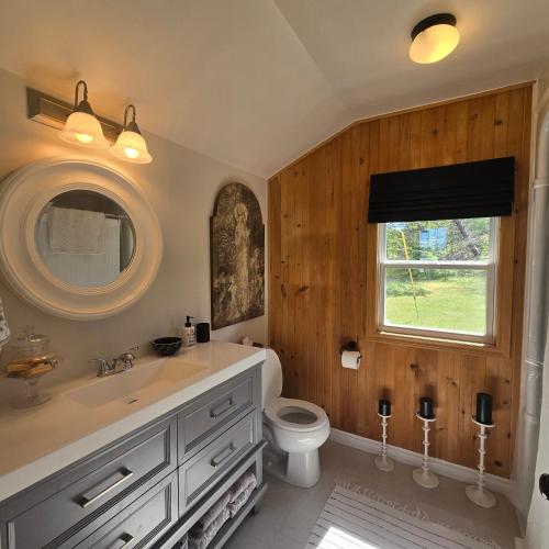 a bathroom with a sink and a toilet and a window at Brackley Beach Schoolhouse in Brackley Beach