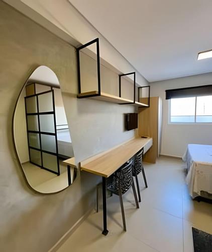 a room with a table and a mirror and a bed at Studio Moderno Westfit - Barreto in Mossoró