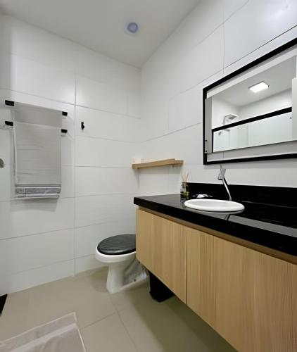 a bathroom with a toilet and a sink and a mirror at Studio Moderno Westfit - Barreto in Mossoró