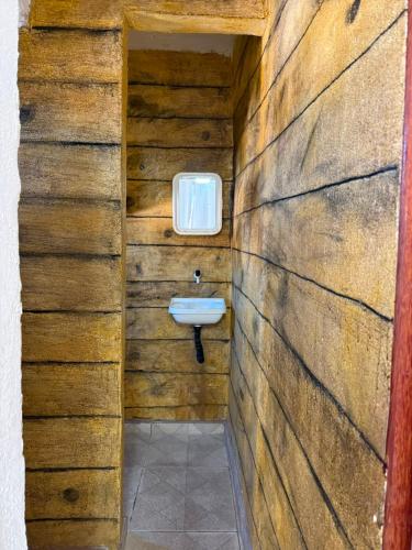 a bathroom with a sink in a wooden wall at Suites Prime in Marataizes