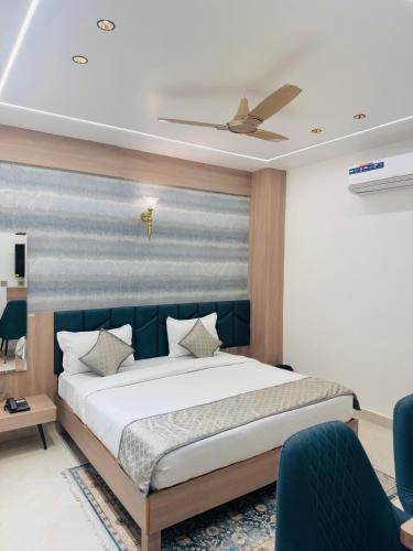 a bedroom with a large bed with a blue headboard at Hotel Meridian in Jagādhri
