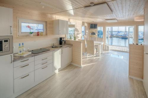 eine große Küche mit weißen Schränken und einem großen Fenster in der Unterkunft Ostsee Hausboot Swantje in Heiligenhafen