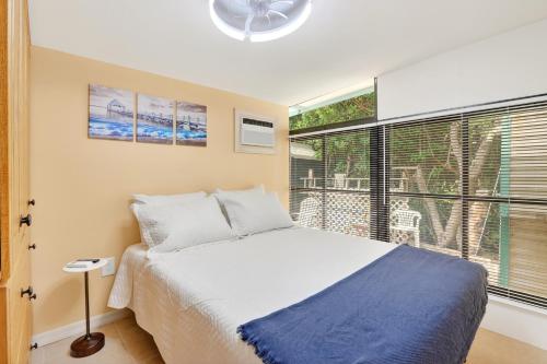 a bedroom with a bed and a large window at Key Largo Tiny House, Marina, Beach, and Pool Access in Key Largo