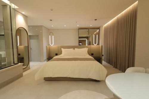 a bedroom with a large bed and a table at Grand Maison Hotel in Porto Velho