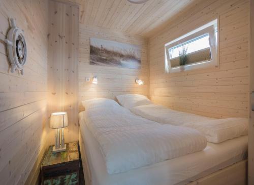 1 Schlafzimmer mit 2 Betten in einem Holzzimmer in der Unterkunft Ostsee Hausboot Swantje in Heiligenhafen