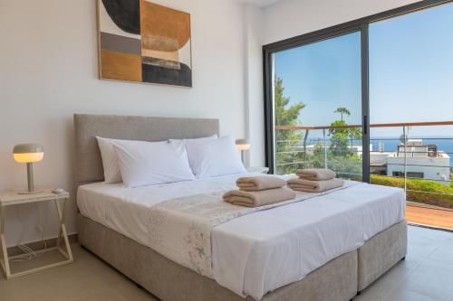 a bedroom with a large bed with towels on it at Esprit Villas in Polis Chrysochous