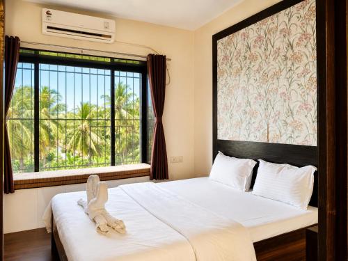 a bedroom with a bed and a large window at The Alibag Beach hotel- Grantley in Alībāg