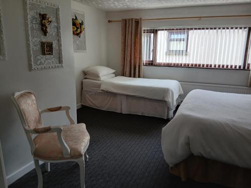 a hotel room with two beds and a chair at Heskin Farm in Burscough