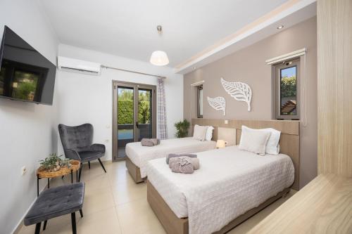 a hotel room with two beds and a tv at Villa Vatia 1 in Tragaki