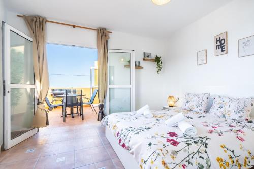 a bedroom with a bed and a balcony with a table at Casa Susa in Adeje