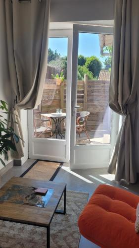 a living room with a door open to a patio at studio douillet en centre bourg in La Plaine-sur-Mer