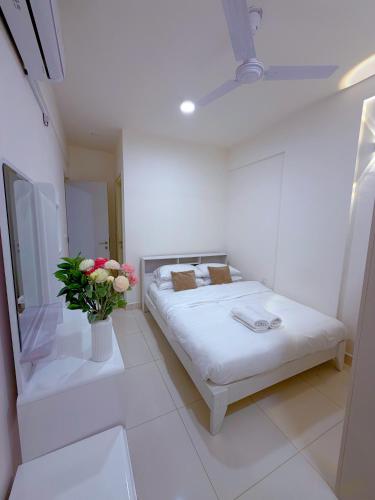 a white room with a bed and a vase of flowers at Minique stay - spacious 3BR in Furena