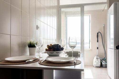 a kitchen with a counter with two plates and wine glasses at Douro View by Porto in Valbom