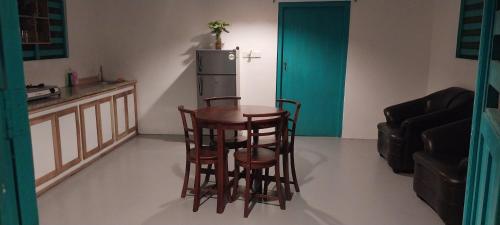 a kitchen with a table and two chairs and a refrigerator at Sun Rock Villa Arugambay in Arugam Bay