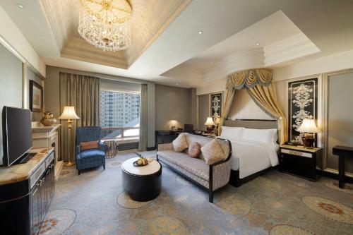 a hotel room with a bed and a couch and a television at InterContinental Lhasa Paradise by IHG in Lhasa