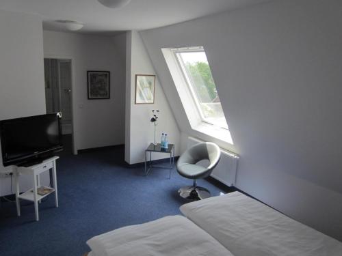 a bedroom with a bed and a desk and a window at Hotel Haus Thoeren in Kerken