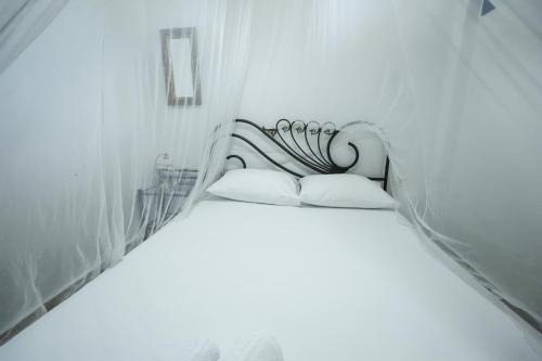 a white room with a bed with two pillows at Efi Pool & View Alepochori i in Kato Alepochori