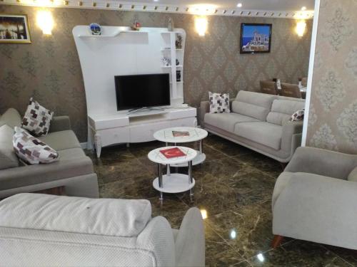 a living room with two couches and a tv at Send Apart Otel in Antalya