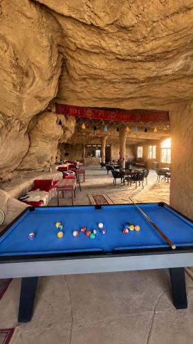 a pool table in front of a stone cave at Adel Wadi Rum Camp Bubble in Disah