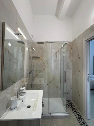 a white bathroom with a shower and a sink at Scilla Central Rooms in Scilla