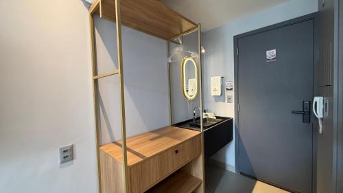 a bathroom with a sink and a mirror next to a door at Acqua Tambaú Luxury Flat 100 meters from the sea in João Pessoa