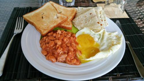 a plate of breakfast food with eggs beans and toast at Nolhi Escape in Nolhivaranfaru