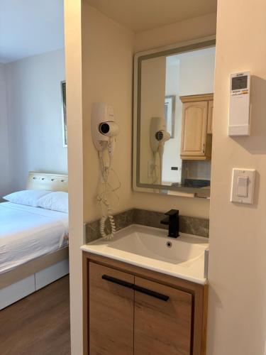 a bathroom with a sink and a mirror and a bed at Dragon Gate Inn in Toronto