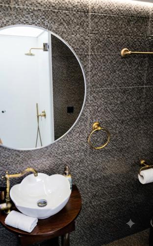 a bathroom with a white sink and a mirror at Halil Bey Luxury Apartments in Kavála