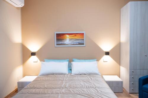 a bedroom with a large bed with two lamps at B&B Civico 15 in Nettuno