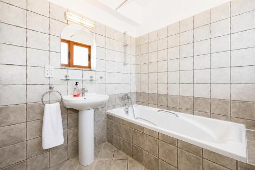 a bathroom with a sink and a bath tub at Villa Argaka Heights in Argaka