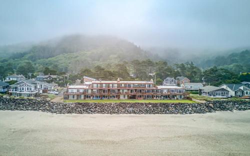 a large building in front of a mountain with houses at Pacific Sands Unit #10 in Neskowin
