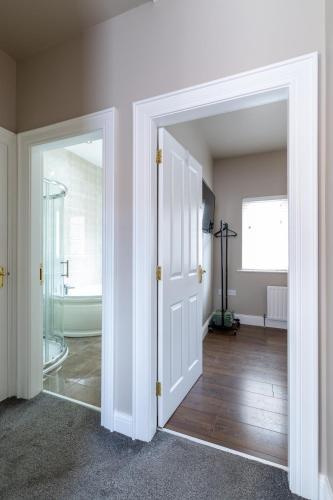 an open door to a bathroom with a tub at 18 Garden Mews in Cookstown