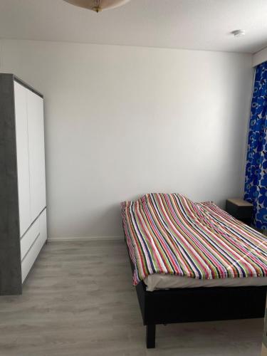 a bedroom with a bed and a white wall at Kasakankuja Kajaani in Kajaani