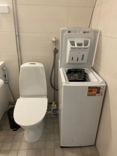 a small bathroom with a toilet and a machine at Kasakankuja Kajaani in Kajaani