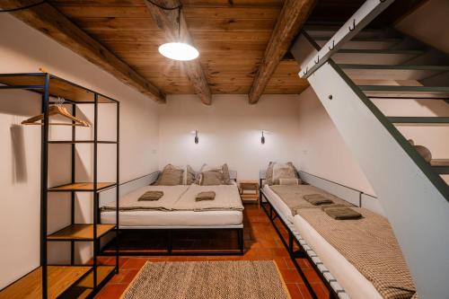 two beds in a room with a staircase at Statek u Benešů in Ponědraž