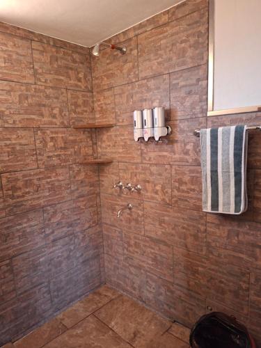 a bathroom with a wooden tiled wall with a towel at Cabaña Terracota in Maimará