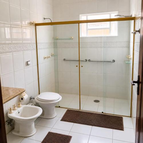 a bathroom with a shower with a toilet and a sink at Pousada Bem Estar Frutal in Frutal