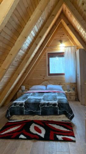 a bed in the attic of a log cabin at Vila Paradiso in Slatina Varoš
